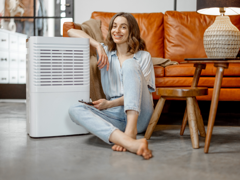 Girl sitting near air purifier and smiling