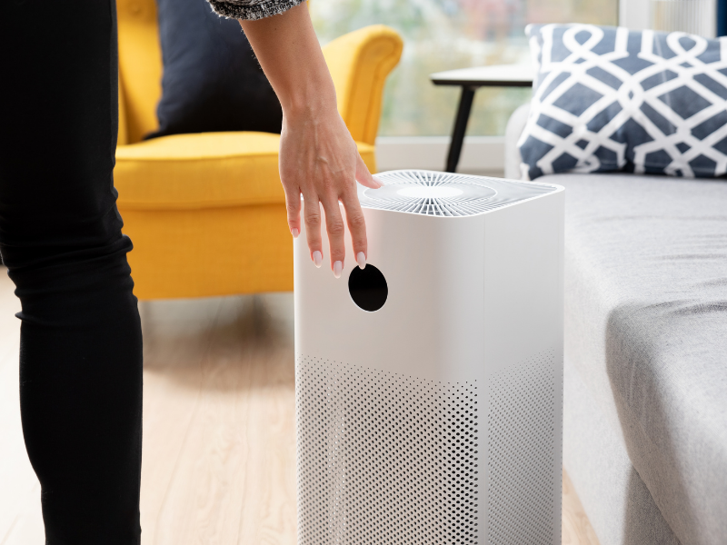 Woman touches air purifier with her hand